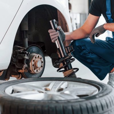 mechanic-inspecting-a-shock-absorber-near-a-vehicl-2026-09-22-02-57-42-utc-scaled.jpg